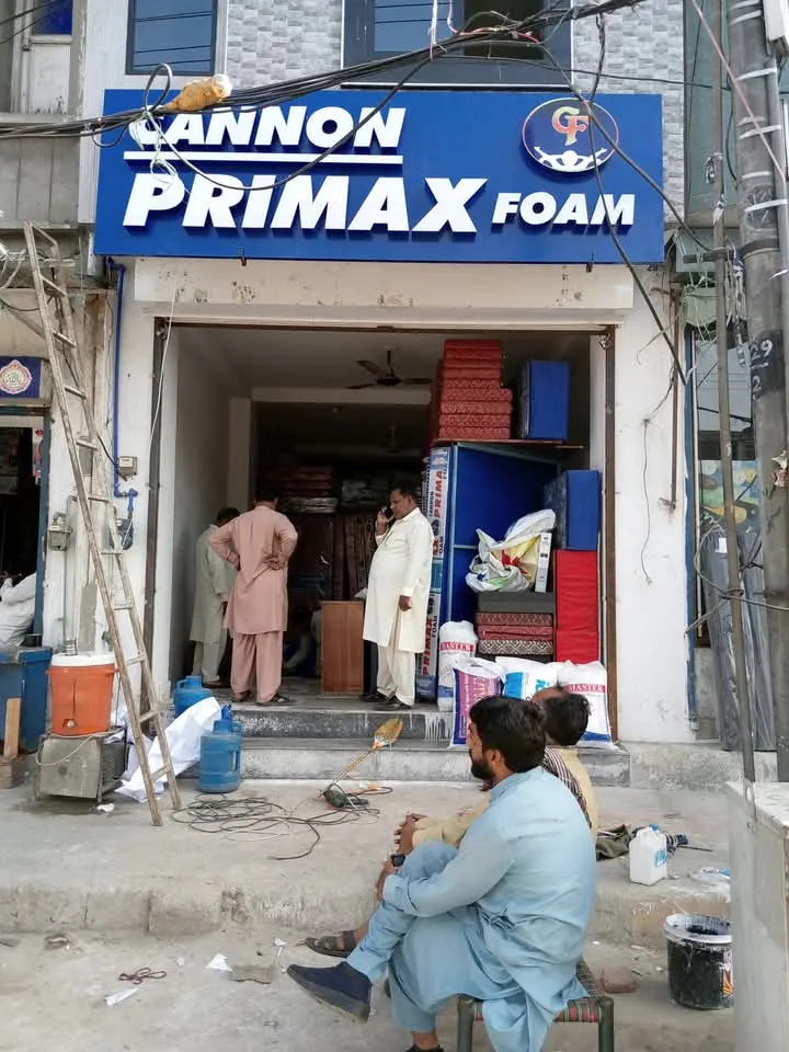 A team fitting a large shopfront board from ladders